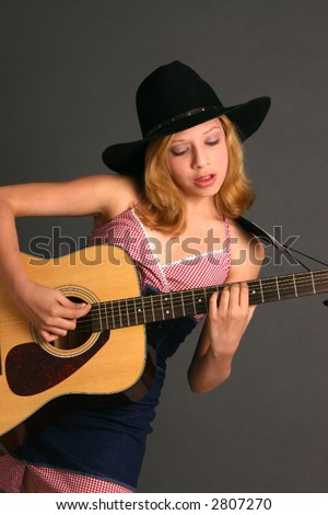 Teenage girl in country western outfit with guitar