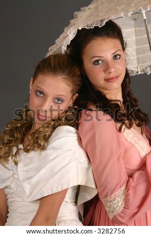 Teenage sisters in period costumes with jewelry and parasol