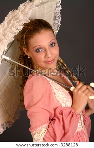 Blond teenage girl with parasol and wearing period costume dress