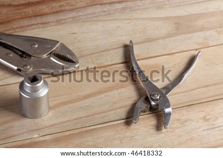 Locking pliers slip joint pliers socket wrench on a weathered wooden plank deck