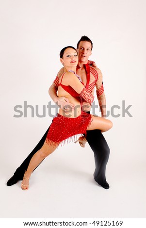 Man and woman ballroom dancers in exotic costumes  perform before a white background