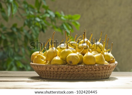 yellow pears in basket on wooden
