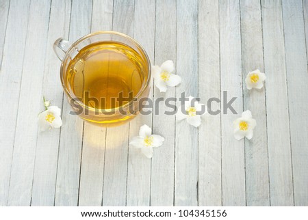 jasmine tea and jasmine flowers on white wooden background, top view