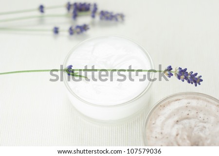 face cream and hand cream with blue lavender flowers on white textile background