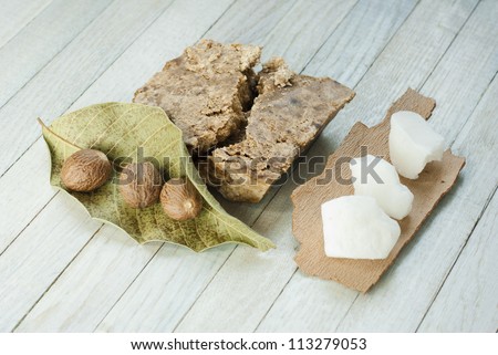 handmade african black soap and ingredients, shea butter nuts, leaves and white shea butter