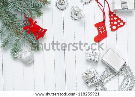 red felt christmas ornaments with pine branch on white wooden table background