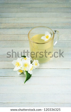 jasmine tea, jasmine flowers and lemon on bright wooden table