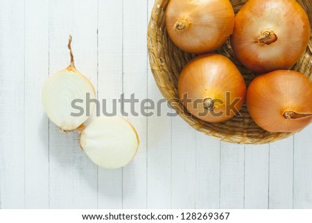 red onions in rustic bowl directly above, white wood table background