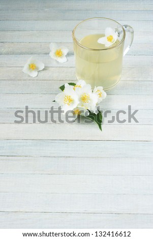 jasmine tea, jasmine flowers and lemon on bright wooden background