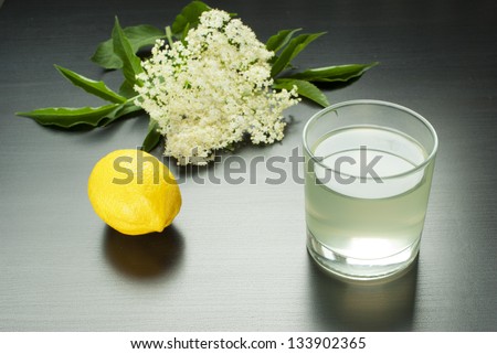glass of natural elder flower juice with lemon and elder flowers