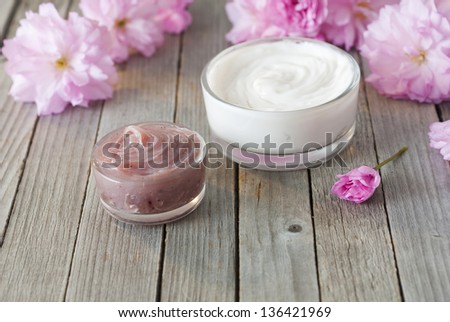 cosmetic cream with japanese cherry blossoms on old weathered wooden table background