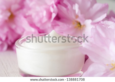 natural facial cream with beauty japanese cherry blossoms on white wood