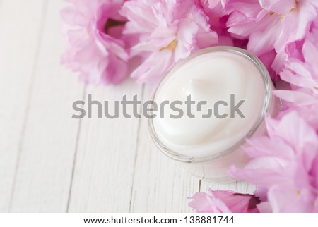 natural facial cream with beauty japanese cherry blossoms on white wood