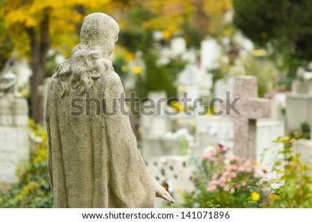 Jesus Christ statue in a cemetery at fall
