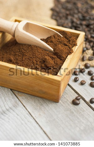 coffee beans, ground coffee with wooden spoon on rusty wood background