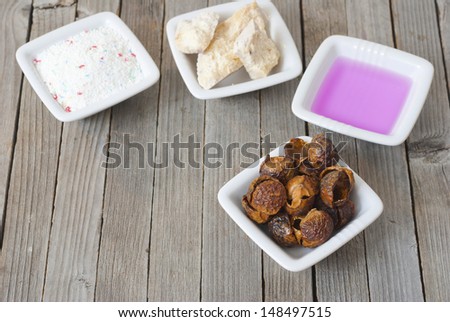 environmentally friend soapnuts and other traditional and modern washing chemicals on wooden surface
