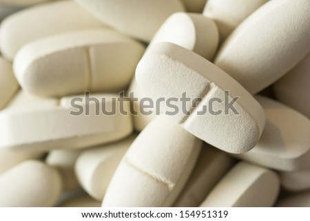 vitamin pills on white surface