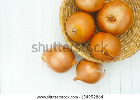 red onions in rustic bowl, white wood table background
