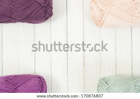 balls of wool on white wood surface