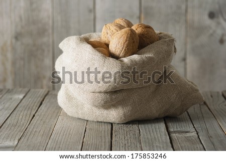 walnuts in cotton bag on old wood table