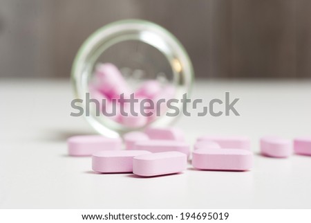 pink vitamin pills on white table
