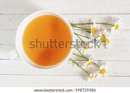 cup of chamomile tea on white wooden table