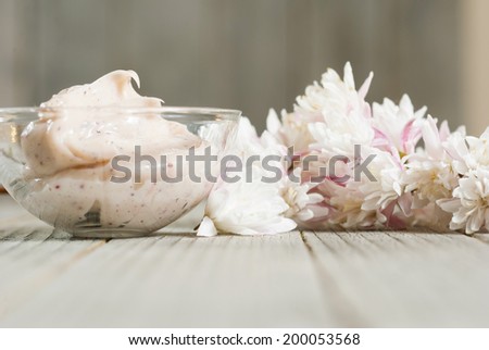 cosmetic cream  and flowers on old wood background