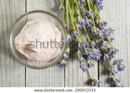 cosmetic cream and lavender flowers on old wood background