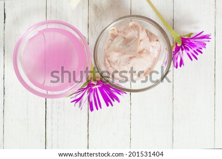 anti aging product with herbal flowers on white wood table