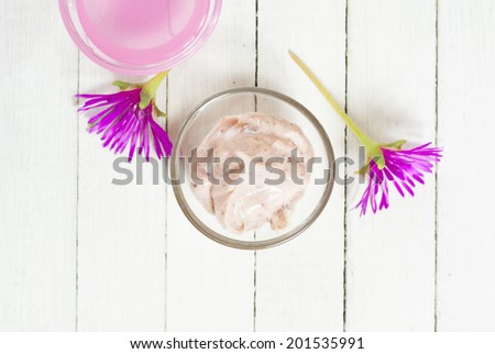 anti aging product with herbal flowers on white wood table