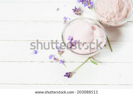 cosmetic cream with lavender flowers on white wood table