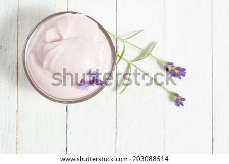 cosmetic cream with lavender flowers on white wood table