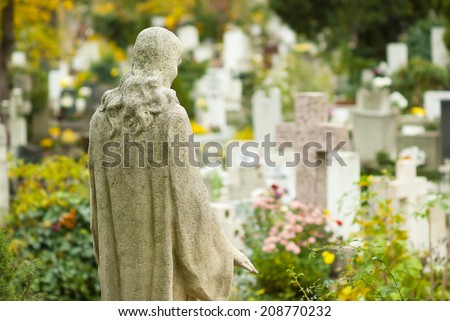 Jesus Christ statue in a cemetery at fall