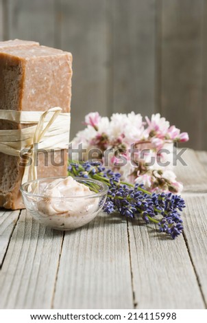cosmetic cream, soap blocks and lavender flowers on old wood background