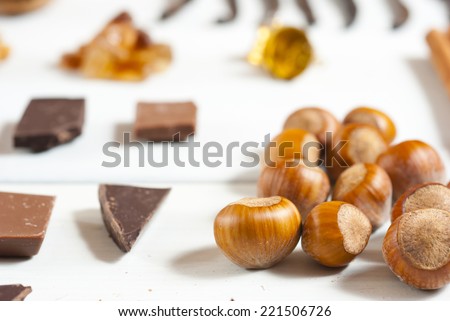 dessert ingredients and chocolate blocks in a row on white wooden table background