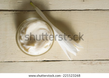cosmetic cream with white flower on rusty wooden table