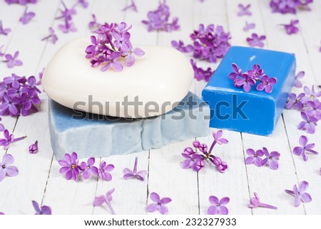 soaps with lilac flowers on white wood table
