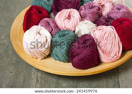 balls of wool on bamboo dish, rusty wood table background