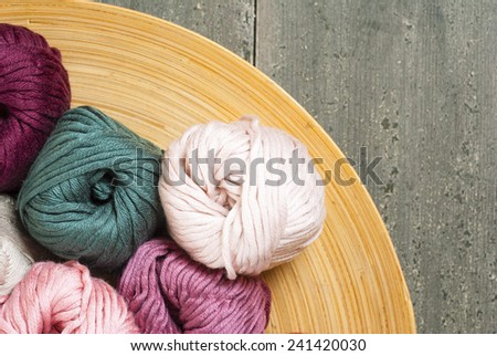 balls of wool on bamboo dish, rusty wood table background