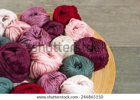 balls of wool on bamboo dish, rusty wood table background