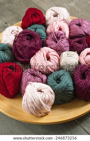 balls of wool on bamboo dish, rusty wood table background