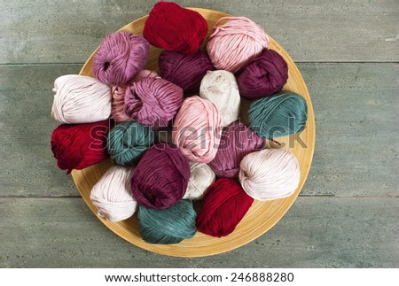 balls of wool on bamboo dish, rusty wood table background