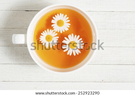 cup of chamomile tea on white wooden table