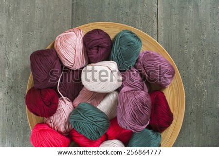 balls of wool on bamboo dish, rusty wood table background