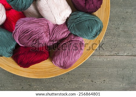 balls of wool on bamboo dish, rusty wood table background