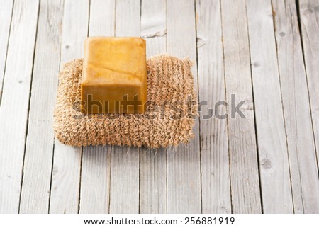 bath sponge and organic soap on natural wooden