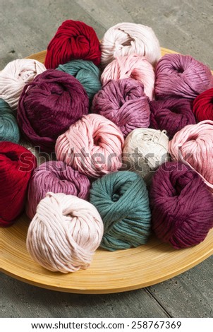 balls of wool on bamboo dish, rusty wood table background