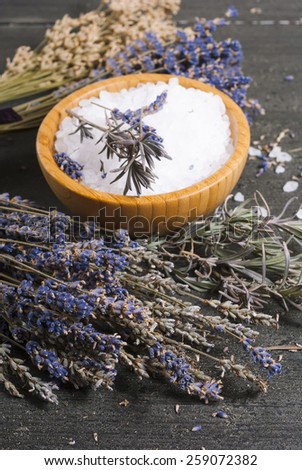 bath salt in bamboo bowl and dried lavender flowers on old black wood table