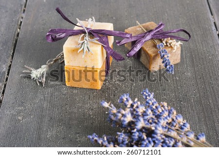 lavender soaps and flowers on rusty black wooden