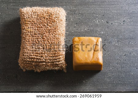 organic soap and bath sponge on dark wooden